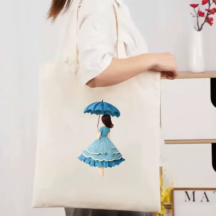 Sac fourre-tout en toile beige avec un imprimé féminin d'un parapluie et une robe bleue, adapté à un
