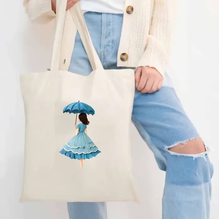 Sac fourre-tout en toile beige avec un imprimé féminin d'un parapluie et une robe bleue