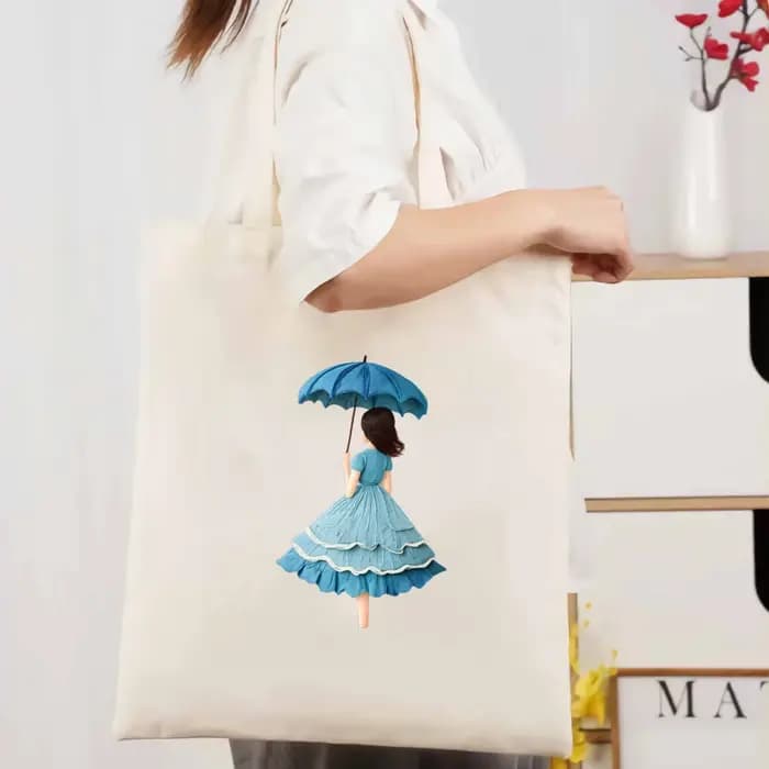 Sac fourre-tout en toile beige avec un imprimé féminin d'un parapluie et une robe bleue